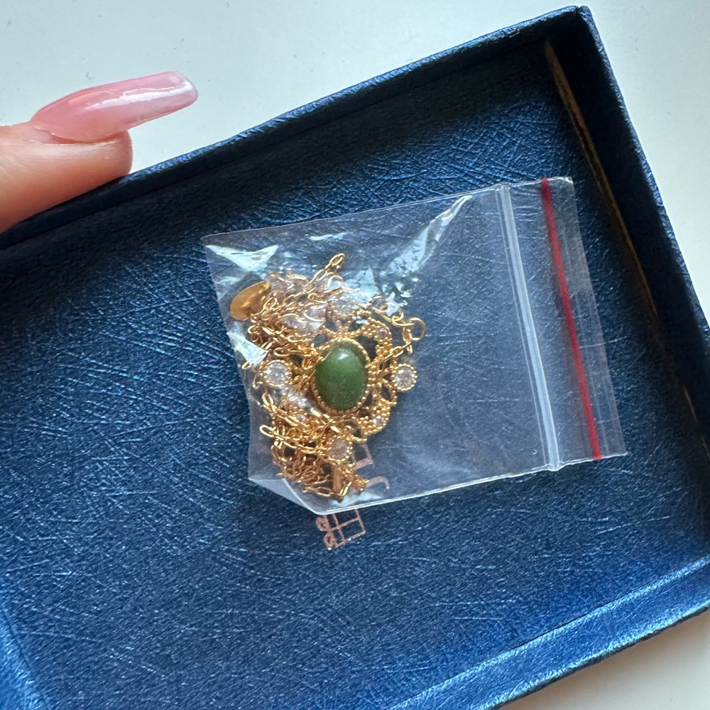 hold necklace with green gem and gems